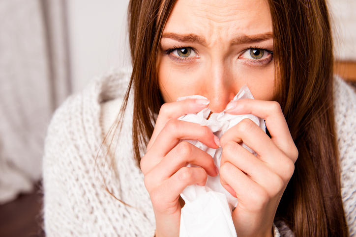 Close up Portrait of Sick Woman with Fever Sneezing in Tissue